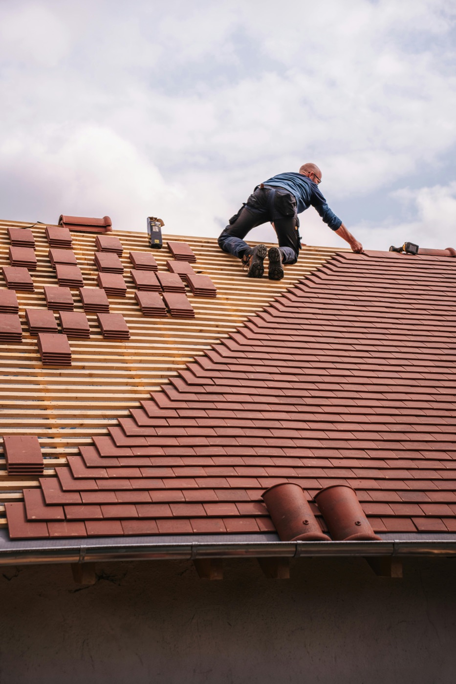 Dachdecker beim Verlegen roter Tonziegel